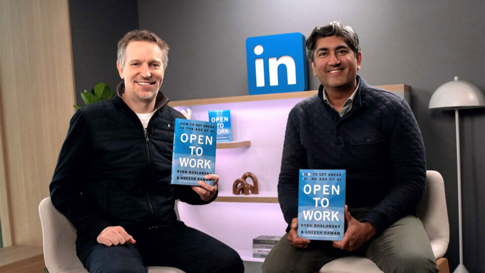 Ryan Roslansky, LinkedIn CEO and EVP of Microsoft Office, and Aneesh Raman, Chief Economic Opportunity Officer, LinkedIn, hold a copy of their book "Open to Work: How to Get Ahead in the Age of AI."